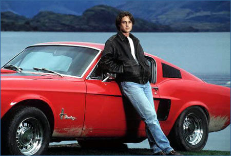 Vin leaning against red car